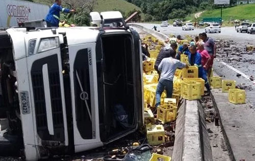 Carreta com bebidas tomba e tem carga saqueada na BR-101