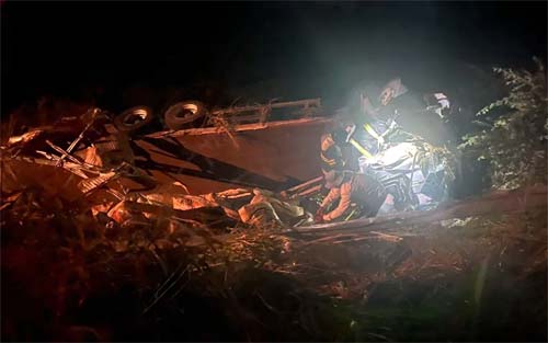 Homem fica ferido após carreta “perder os freios”, capotar e cair em ribanceira