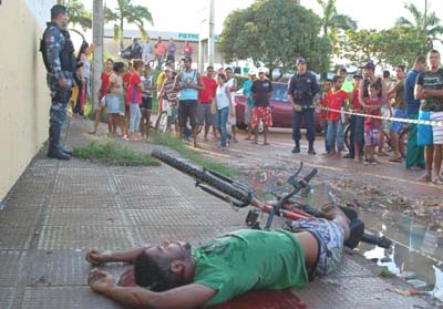 Traficante é morto a tiros por homem de bicicleta .